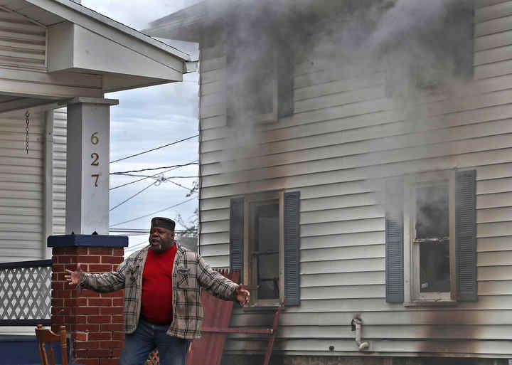 Homeowner Larry Humphrey reacts as smoke billows from the windows of his Southern Avenue home. The house suffered extensive damage by the fire which started in the basement and quickly spread to the first floor. There were no injuries reported but a family dog was killed in the blaze.   (Bill Lackey / Springfield News-Sun)